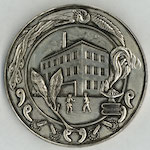 Commemorative medal issued by Shitaya Ward in November 1930, four months after the last of its thirteen primary schools was completed. <br>The medal depicts a girl and a boy running toward the entrance of their new three-story building, complete with a rooftop playground. <br>A phoenix decorates the border to symbolize the new schools rising from the ashes. Beneath the phoenix are symbols of learning and spiritual enlightenment, including a burning lamp on top of books and fireflies with glowing tails. <br>Source: Medal, 1930